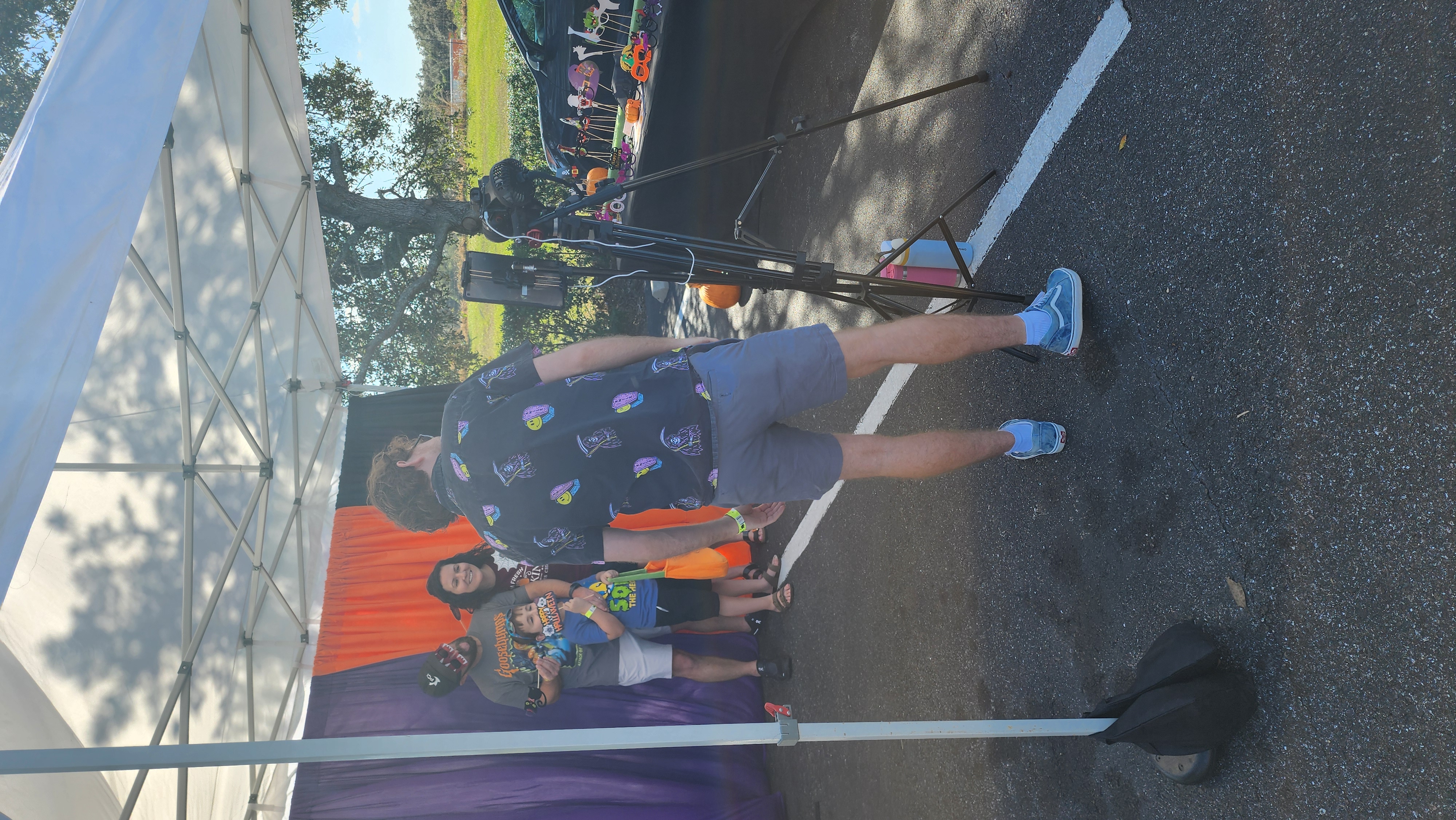 Family taking a Halloween photo at the Dinosaur World event while a Plant City Event Rentals employee operates the photo booth